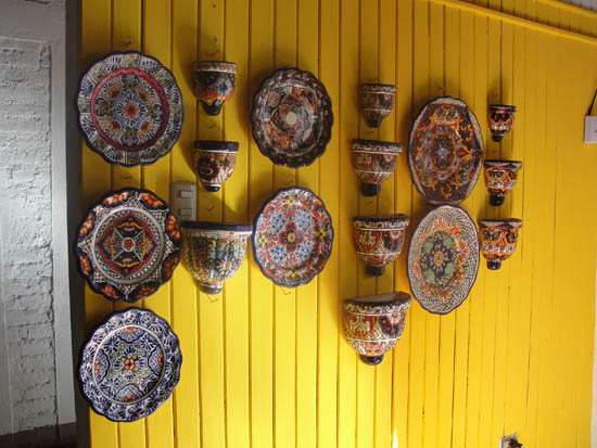 Talavera pottery pops against a yellow wall at Alter Eco